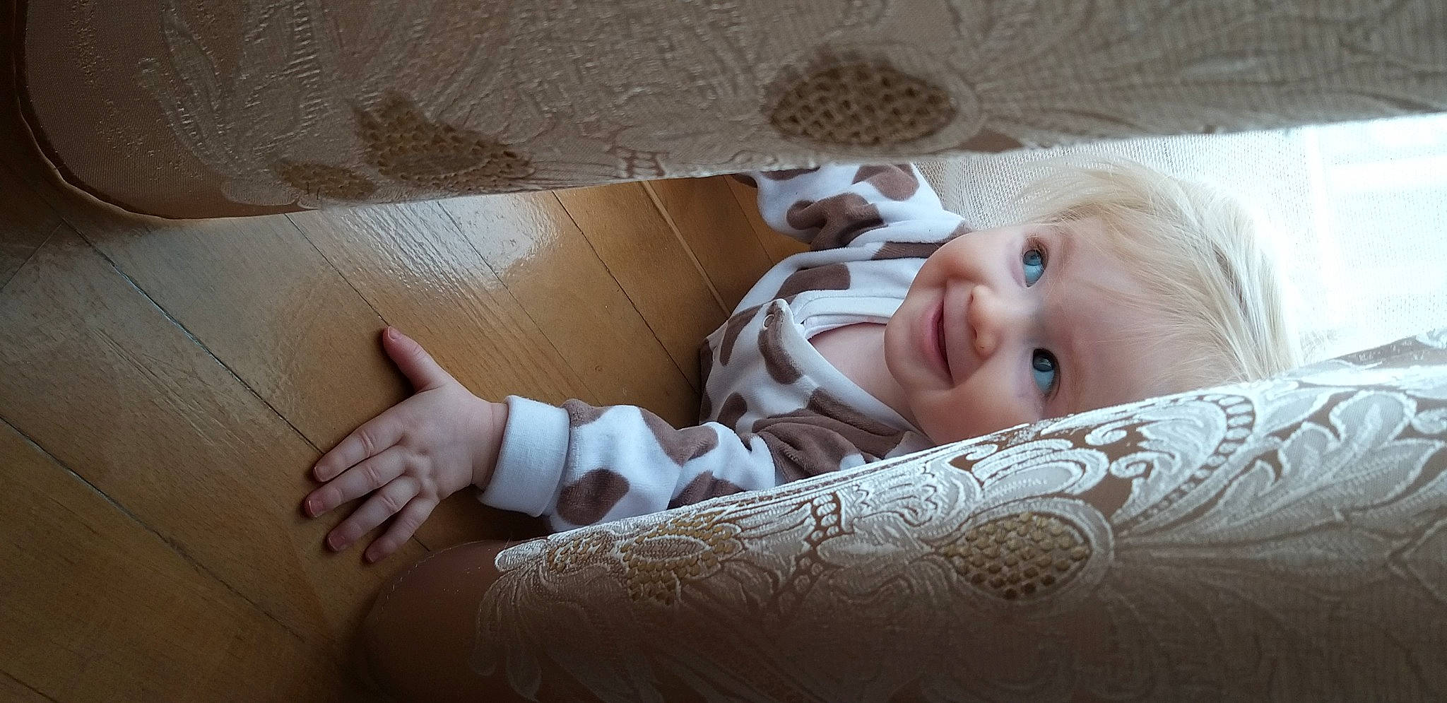 Sara participe au concours pour gagner de l'argent avec cette photo : baby, baby_toddler_clothing, bedding, child, comfort, elbow, finger, floor, flooring, hardwood, human_leg, linens, pattern, person, room, skin, smile, toddler, vertebrate, wood