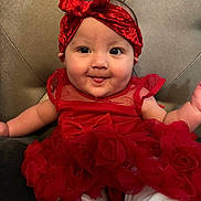 Jailyah is registered to the contest to win money with this photo: baby, child, closeup, clothing, cute, fabric, face, fancy, happy, headband, headwear, indoors, infant, person, portrait, red_dress, sitting, smiling, toddler, tongue_out