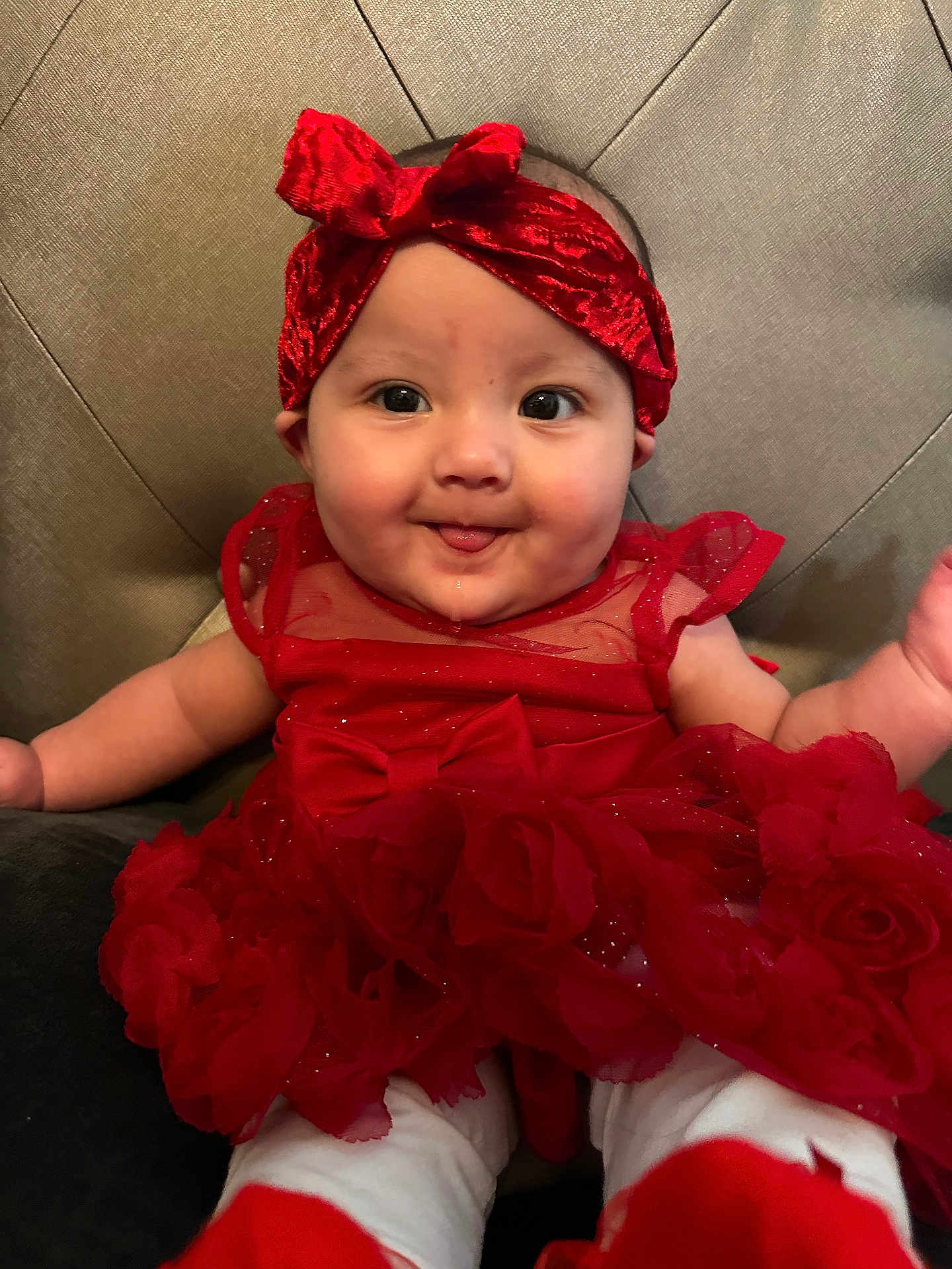 Jailyah is registered to the contest to win money with this photo: baby, child, closeup, clothing, cute, fabric, face, fancy, happy, headband, headwear, indoors, infant, person, portrait, red_dress, sitting, smiling, toddler, tongue_out
