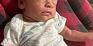 Kaliyah is registered to the contest to win money with this photo: baby, sleeping, headband, flower, infant, pink_pants, white_shirt, floral_pattern, red_pajamas, plaid, child, relaxation, cute, indoors, person, peaceful, closeup, rest, soft_lighting, comfort
