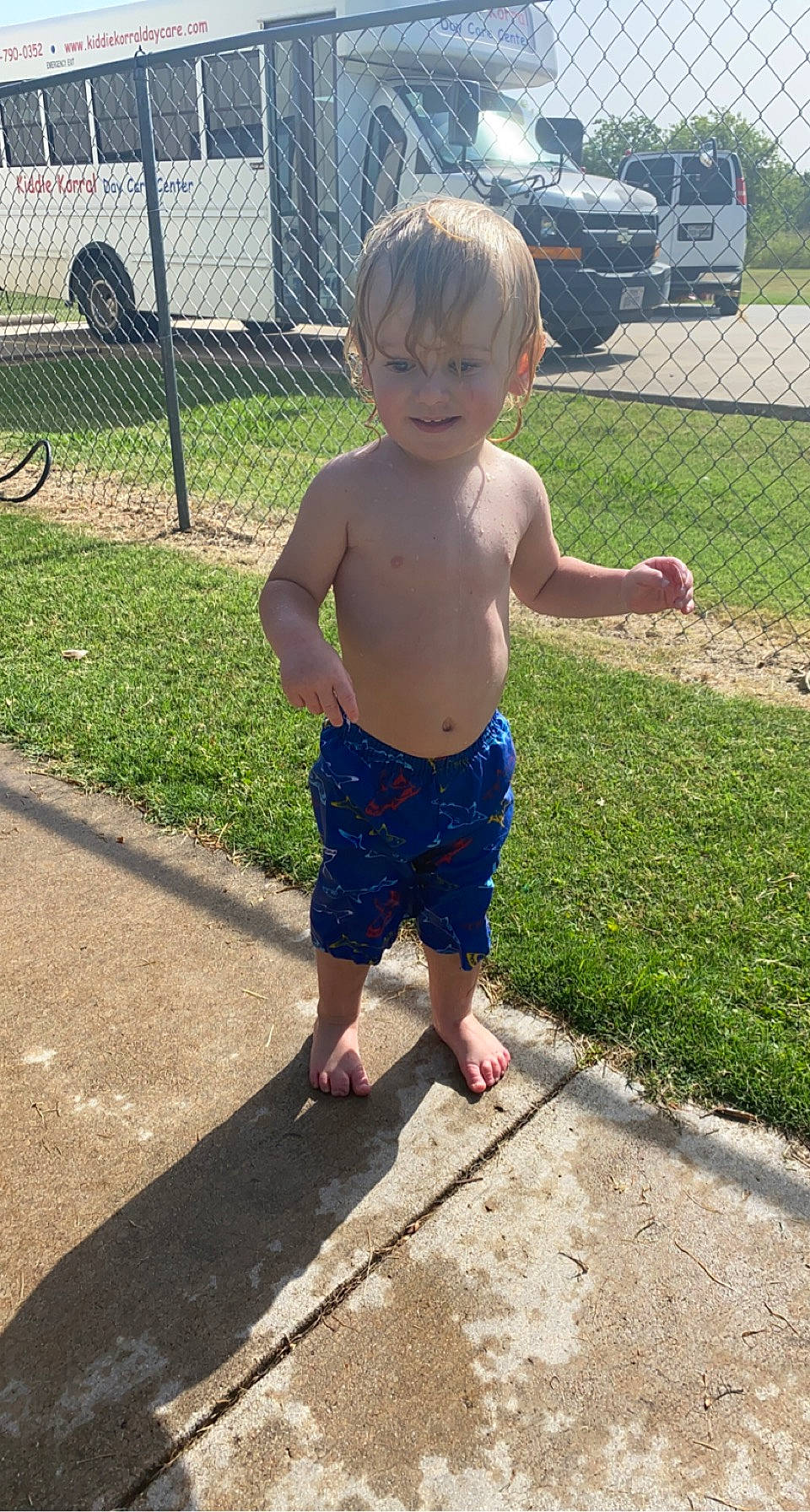 Keagan is registered to the contest to win money with this photo: barechested, barefoot, child, electric_blue, fence, foot, fun, grass, human_leg, leg, leisure, people_in_nature, person, plant, recreation, thigh, tire, toddler, trunk, waist