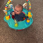 Luka is registered to the contest to win money with this photo: activity_seat, baby, carpet, child, clothing, colorful, cute, development, face, floor, furniture, head, home, indoor, infant, person, playful, seated, smiling, toy