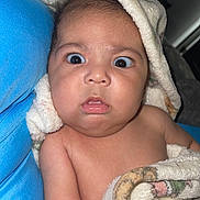 Johan is registered to the contest to win money with this photo: baby, blanket, blue_cushion, child, curious, expression, face, fuzzy, hood, indoor, infant, person, portrait, skin, surprised, toddler, wrapped, young, closeup, soft