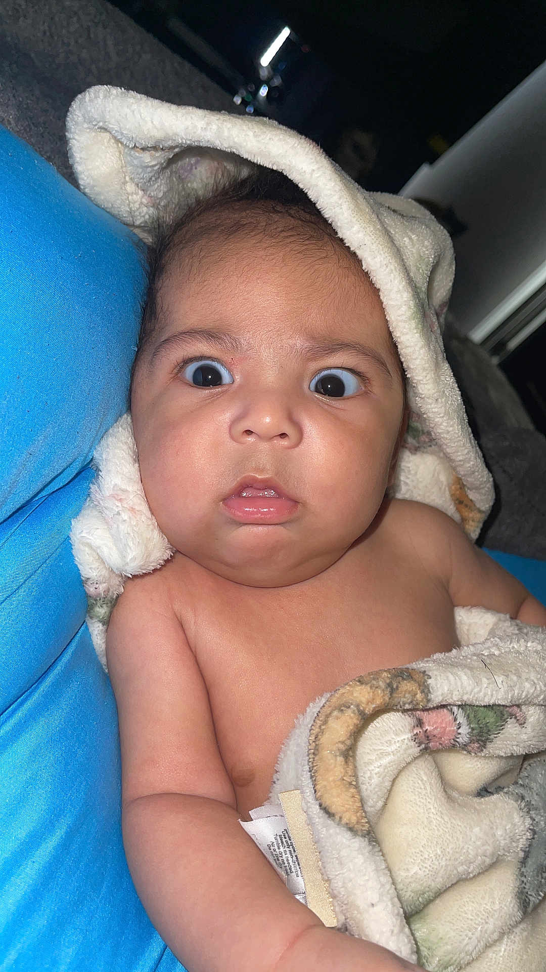 Johan is registered to the contest to win money with this photo: baby, blanket, blue_cushion, child, curious, expression, face, fuzzy, hood, indoor, infant, person, portrait, skin, surprised, toddler, wrapped, young, closeup, soft