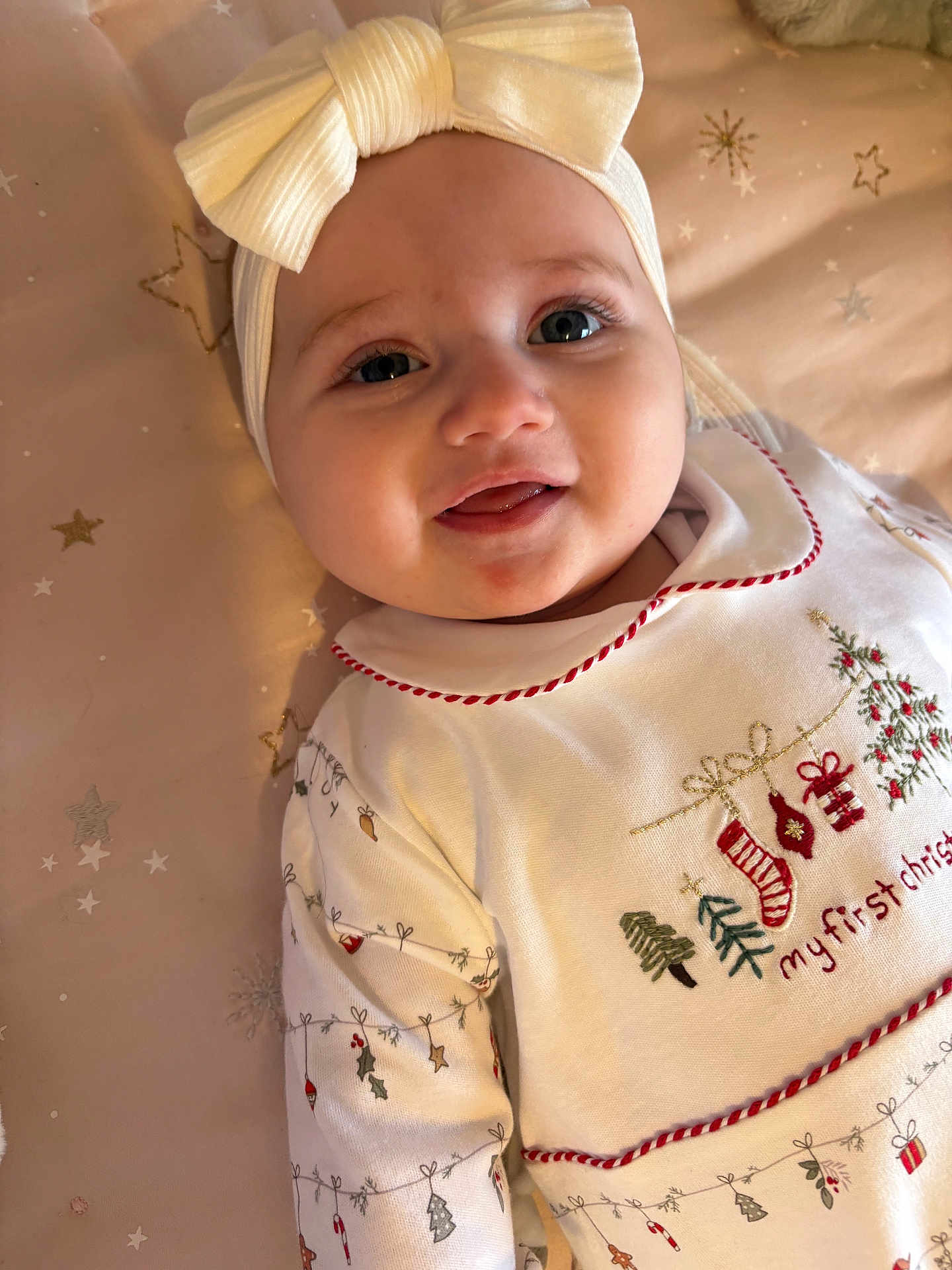 Raya joined the competition — help win amazing prizes! baby, infant, headband, bow, christmas, holiday, festive, smiling, cute, white_clothing, embroidery, face, lying_down, blanket, stars, child, young, indoors, portrait, happy