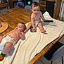 babies, baby, chair, child, curious, diaper, family_photos, floor, furniture, home, indoor, lying_down, person, relaxed, remote_control, sitting, smiling, table, towel, wooden_table