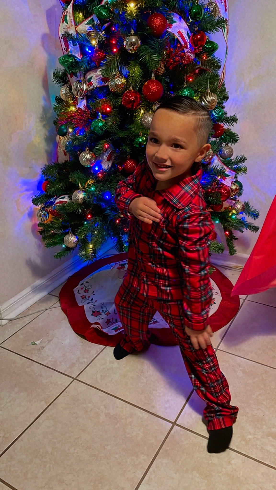 Isaiah is registered to the contest to win money with this photo: christmas, christmas_decoration, christmas_eve, christmas_ornament, christmas_tree, electric_blue, event, fun, happy, holiday, holiday_ornament, joy, ornament, person, plaid, plant, purple, smile, standing, toddler