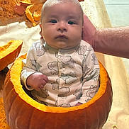 Allen joined the competition — help win amazing prizes! baby, infant, pumpkin, hollowed_pumpkin, elephant_print, onesie, hand, supporting_hand, face, cute, chubby_cheeks, orange, guts, seeds, table_surface, indoor, child, autumn, seasonal, portrait
