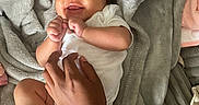 Alayah joined the competition — help win amazing prizes! baby, blanket, child, cozy, cute, hand, happy, indoors, infant, lying_down, person, playful, relaxed, skin, small, smiling, soft_texture, tickling, toddler, white_onesie