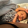 baby, sleeping, infant, blanket, leopard_print, onesie, arm, face, peaceful, soft_lighting, resting, closeup, skin, bed, comfort, indoors, portrait, newborn, cute, relaxation