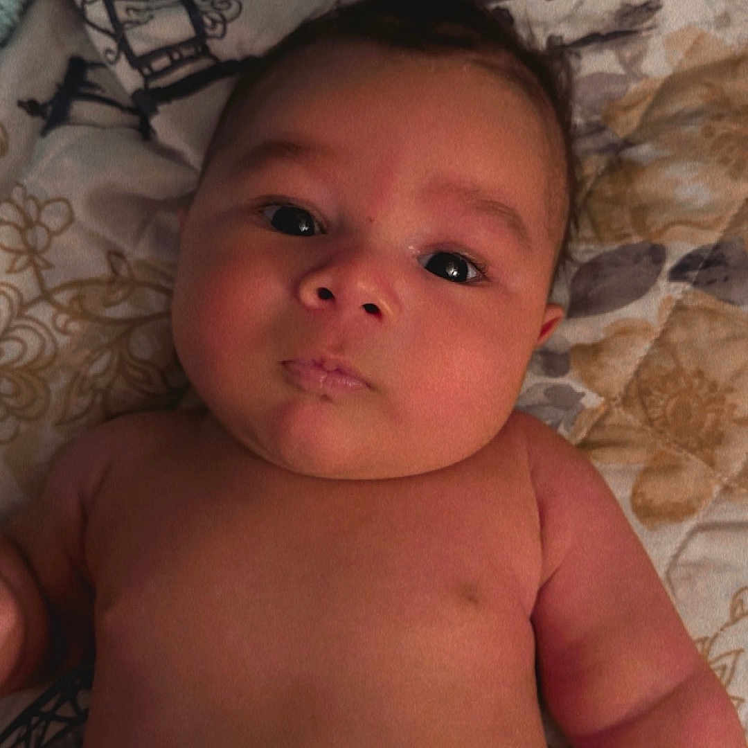 Drayden is registered to the contest to win money with this photo: baby, bed, bedroom, blanket, bodypart, cushion, diaper, face, finger, furniture, head, homedecor, indoors, newborn, person, photography, portrait, quilt, room, towel