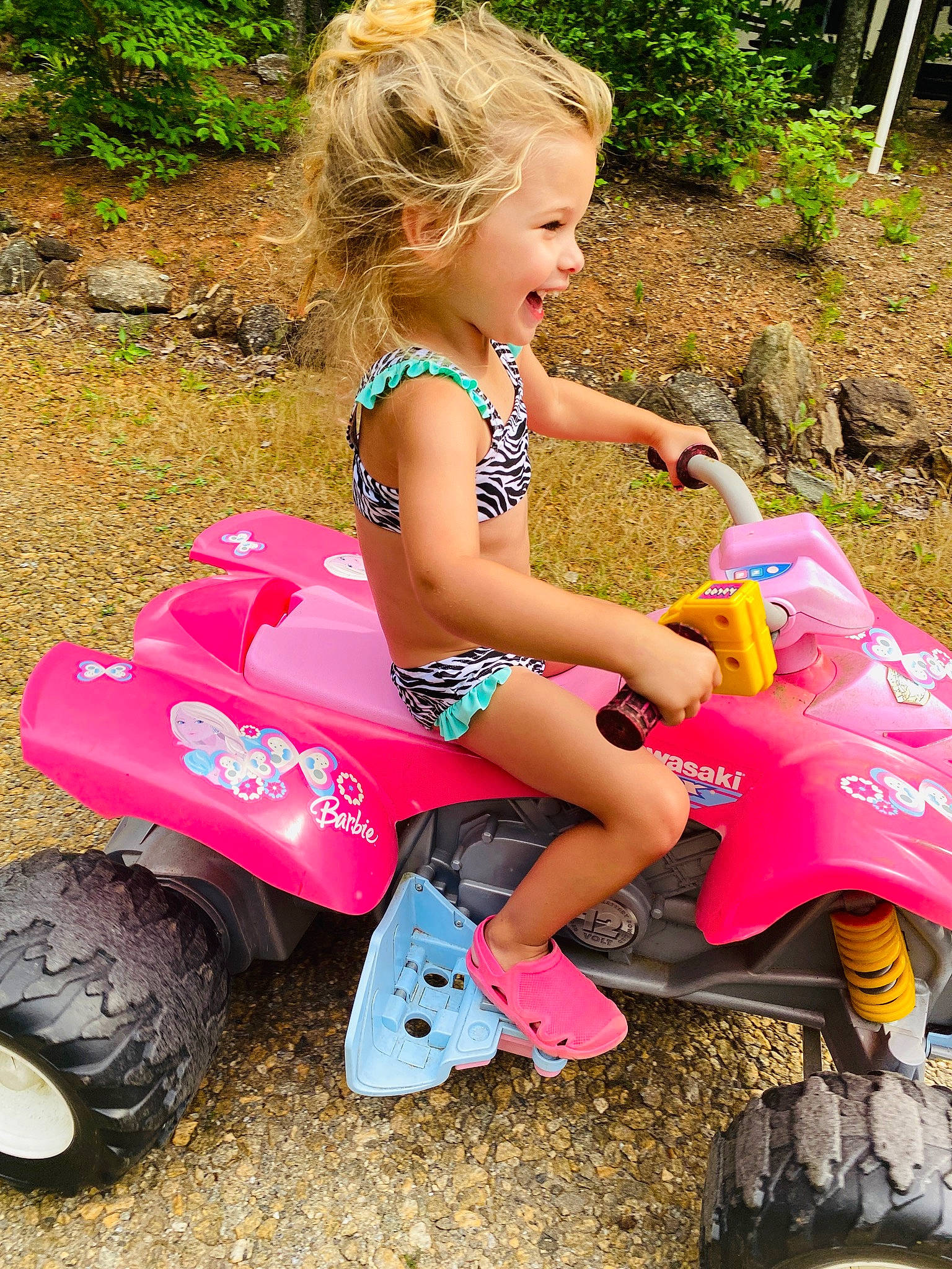 Ember is registered to the contest to win money with this photo: automotive_design, automotive_tire, grass, hairstyle, leisure, motor_vehicle, nature, outdoor_recreation, people_in_nature, person, pink, plant, product, public_space, riding_toy, shoe, shorts, tire, toddler, vehicle