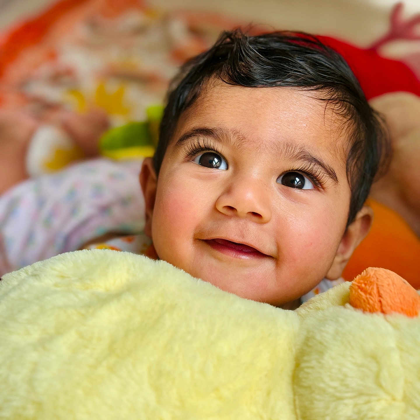 Bodhi is registered to the contest to win money with this photo: baby, child, closeup, comfort, cozy, cute, expression, eyes, face, hair, happy, indoors, infant, plush_toy, portrait, skin, smile, soft, warm, yellow