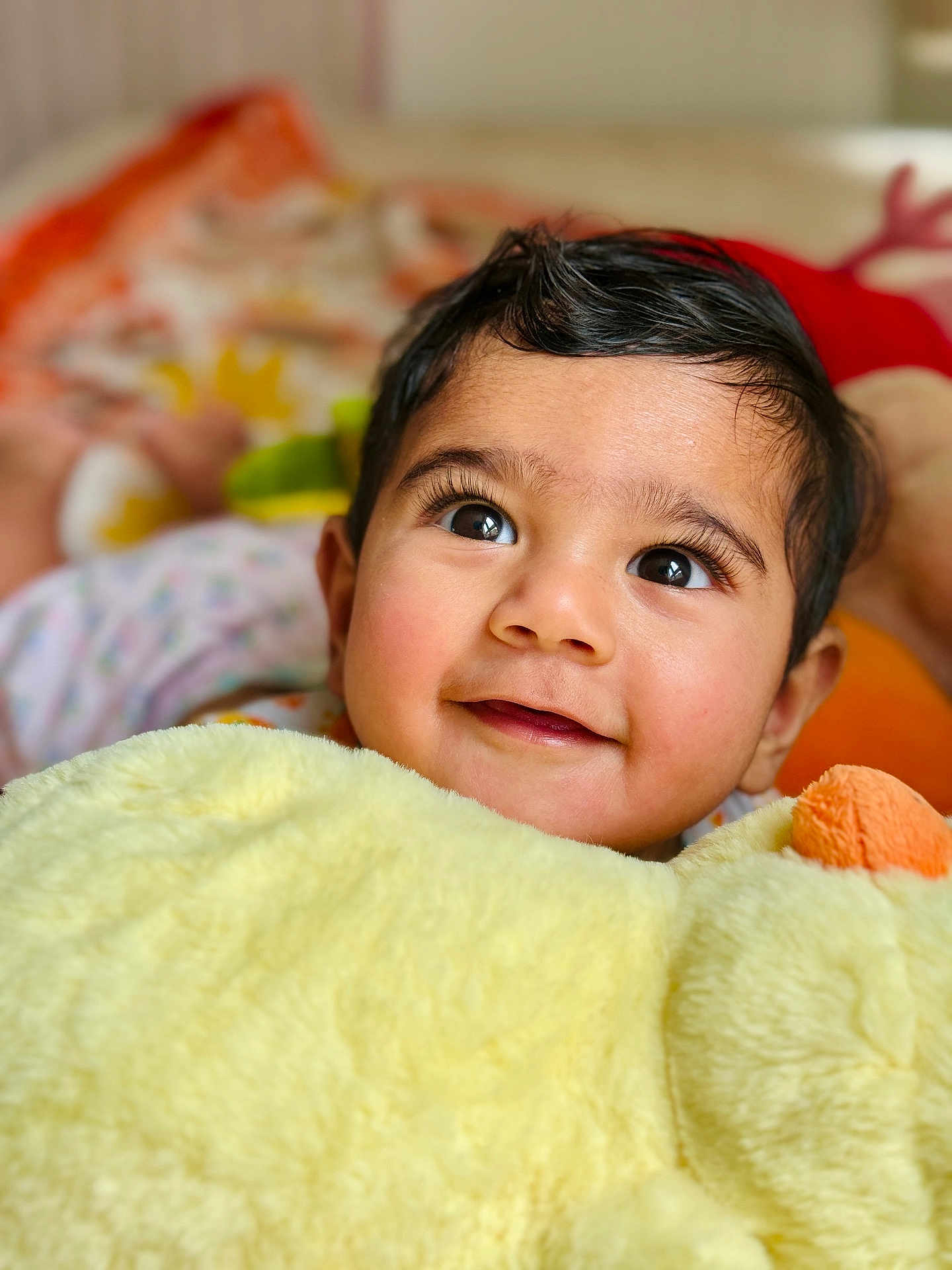 Bodhi is registered to the contest to win money with this photo: baby, child, face, smile, eyes, plush_toy, yellow, soft, cute, portrait, indoors, happy, infant, skin, hair, cozy, expression, closeup, warm, comfort