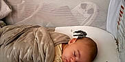 Julius is registered to the contest to win money with this photo: baby, sleeping, crib, blanket, giraffe, zebra, mattress, infant, bedtime, cozy, child, cute, resting, pajamas, soft, indoor, peaceful, wrapped, toddler, nursery