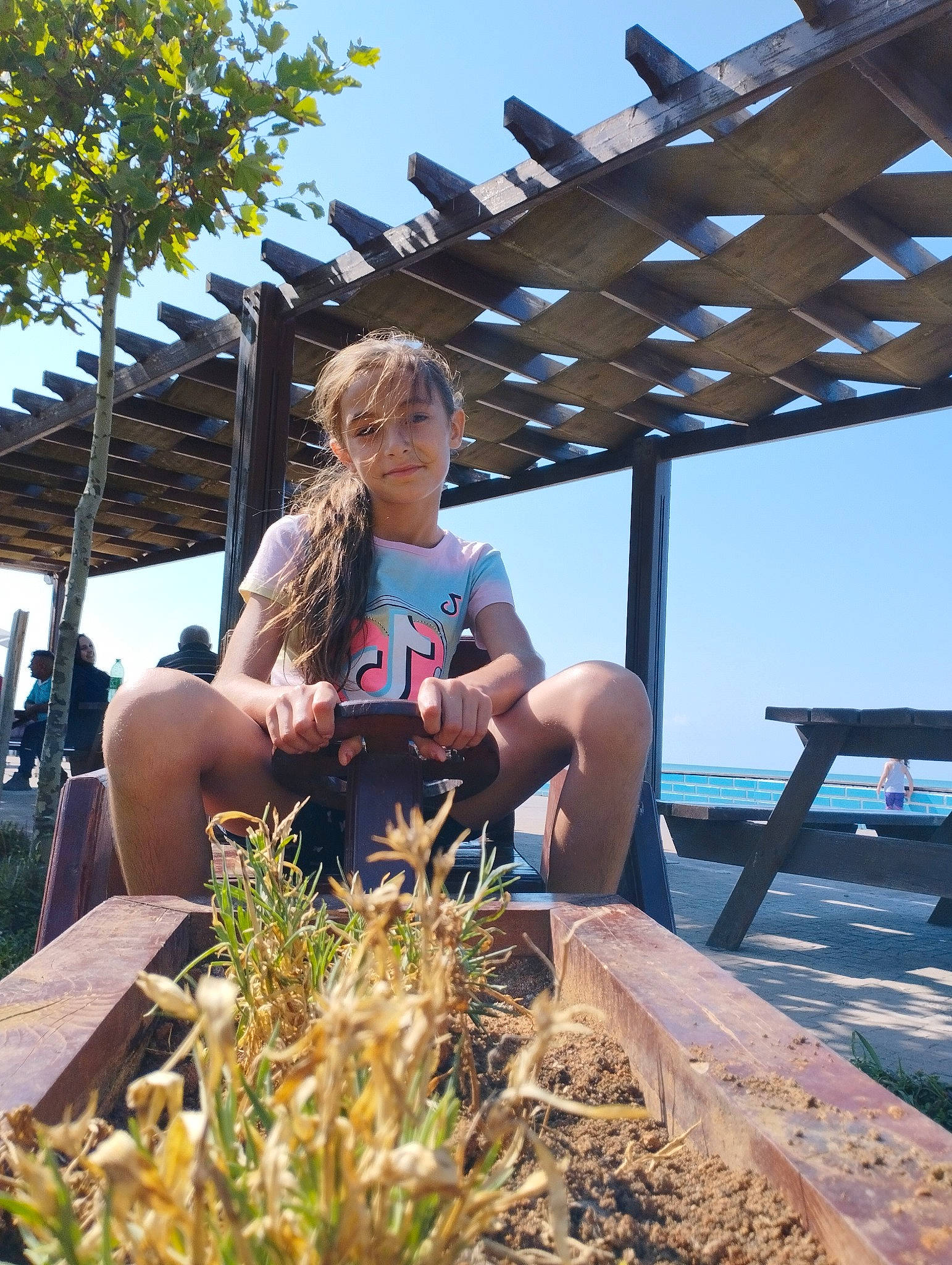 Lelia a rejoint le concours — aidez-le/la à gagner de superbes lots ! chair, event, eyewear, fun, grass, leisure, ocean, people_in_nature, person, plant, recreation, sitting, sky, soil, t_shirt, tourism, travel, tree, vacation, wood