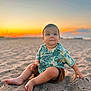 baby, child, toddler, beach, sand, sunset, outdoor, nature, portrait, smiling, cute, summer, vacation, casual_clothing, barefoot, young_child, tropical_shirt, sitting, sky, scenic