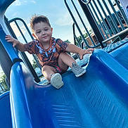 Banks is registered to the contest to win money with this photo: child, toddler, slide, playground, outdoor, blue, smiling, happy, summer, fun, clothing, shorts, shoes, play, recreation, daylight, park, person, young, activity