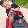 Banks joined the competition — help win amazing prizes! child, toddler, toy_car, red, spray_bottle, smiling, outdoor, sidewalk, grass, suburban, short_hair, black_shirt, green_shorts, playtime, summer, cute, happy, vehicle, person, daytime