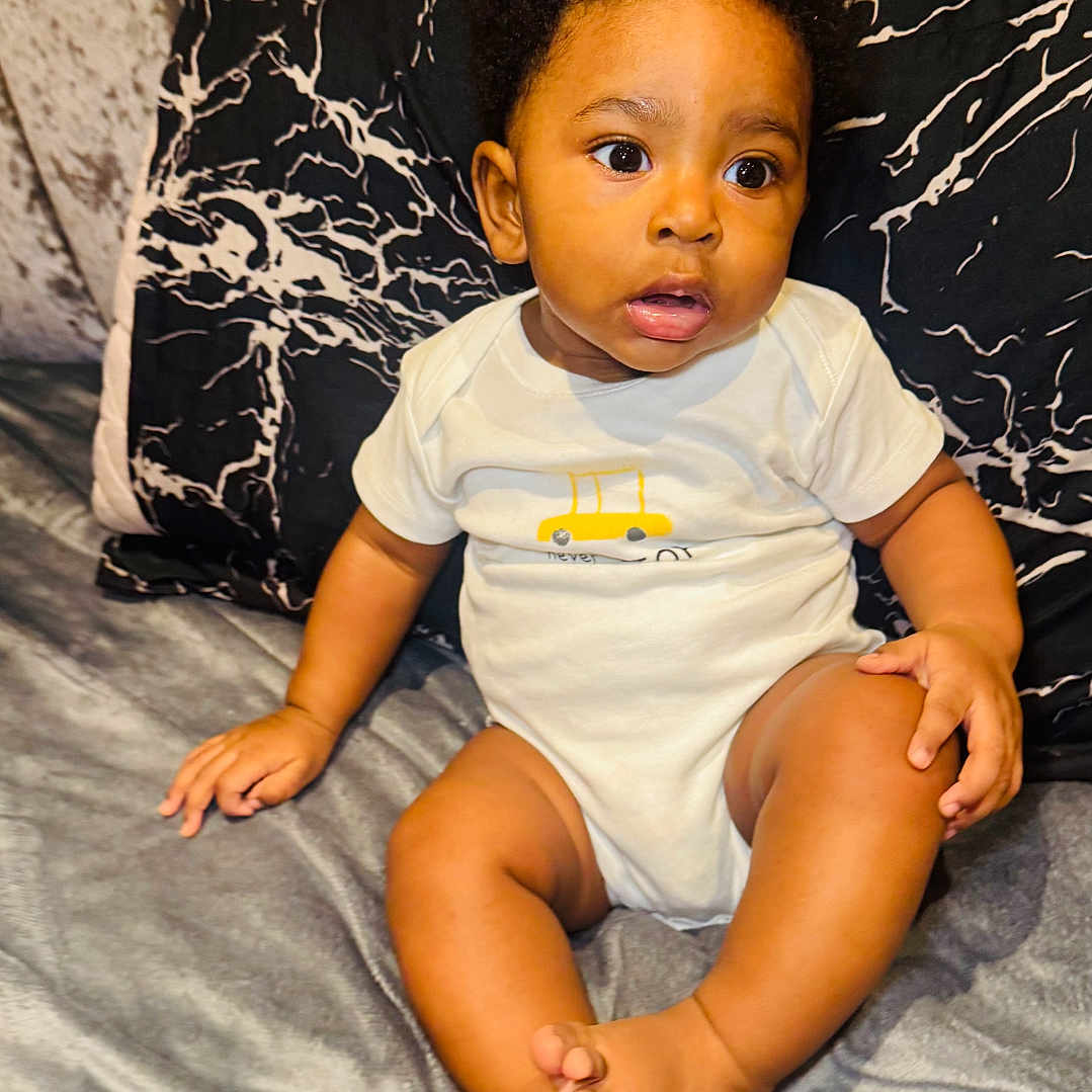 Chinonso joined the competition — help win amazing prizes! baby, bed, bedroom, bodypart, clothing, couch, cushion, face, finger, furniture, hand, head, homedecor, indoors, person, photography, portrait, shorts, sitting, t_shirt