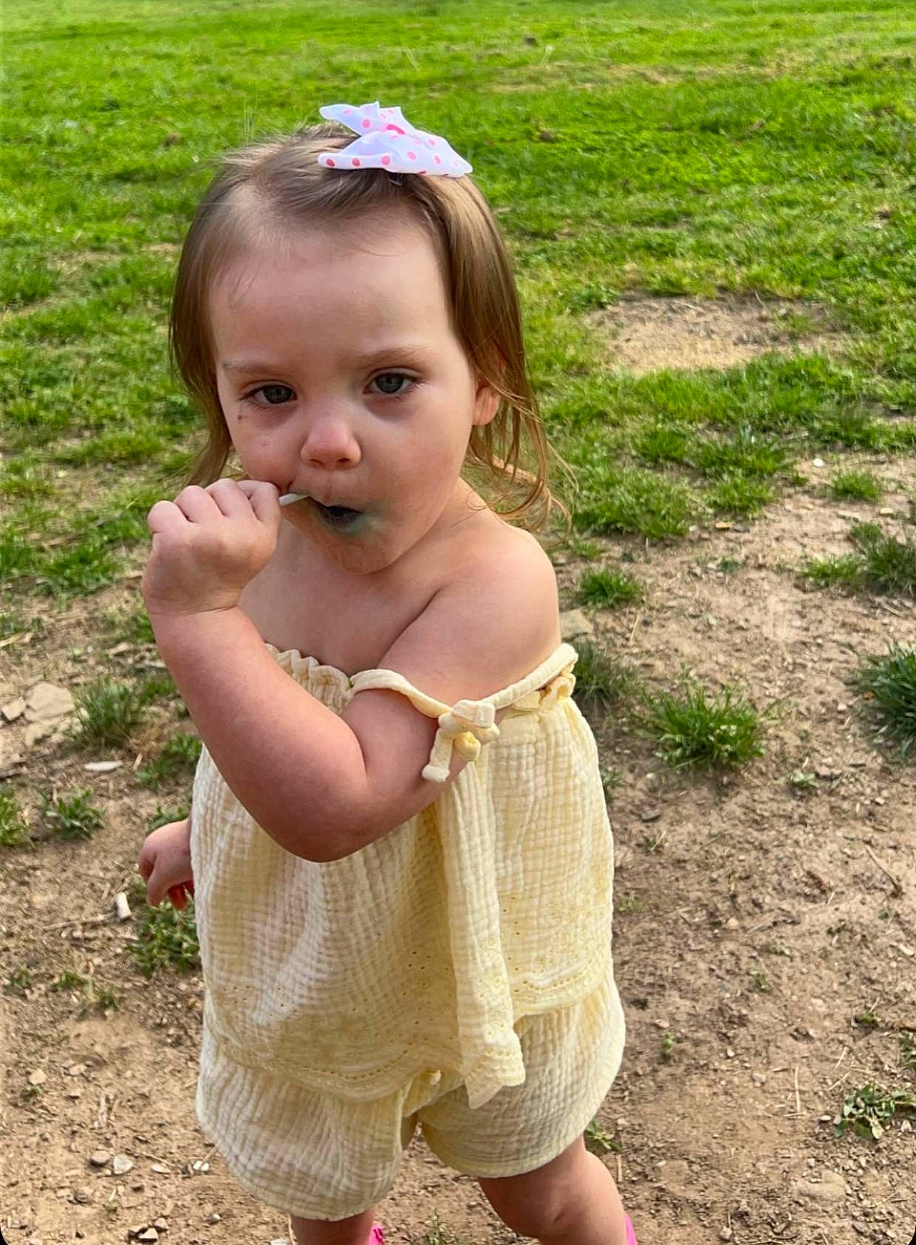 Evie is registered to the contest to win money with this photo: baby_toddler_clothing, blond, child, eye, face, fun, grass, grassland, hair, hand, happy, head, people_in_nature, person, plant, recreation, skin, standing, sunglasses, thumb