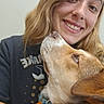 Ace is registered to the contest to win money with this photo: affection, blue_harness, brown_hair, canine, casual_clothing, close_up, collar, dog, friendship, happy, human_animal_bond, indoor, light_background, looking_up, nose_ring, pet, portrait, smile, woman, young_adult