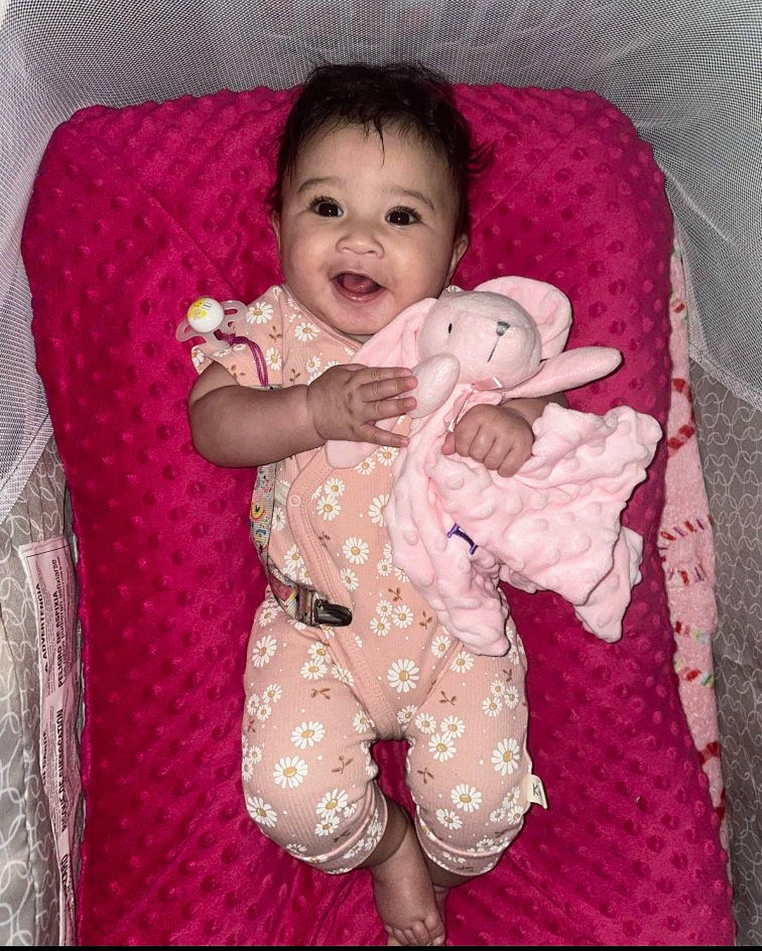 Brielle is registered to the contest to win money with this photo: arm, baby, baby_toddler_clothing, cheek, comfort, eye, face, finger, happy, head, human_body, iris, pattern, person, pink, purple, skin, sleeve, smile, textile