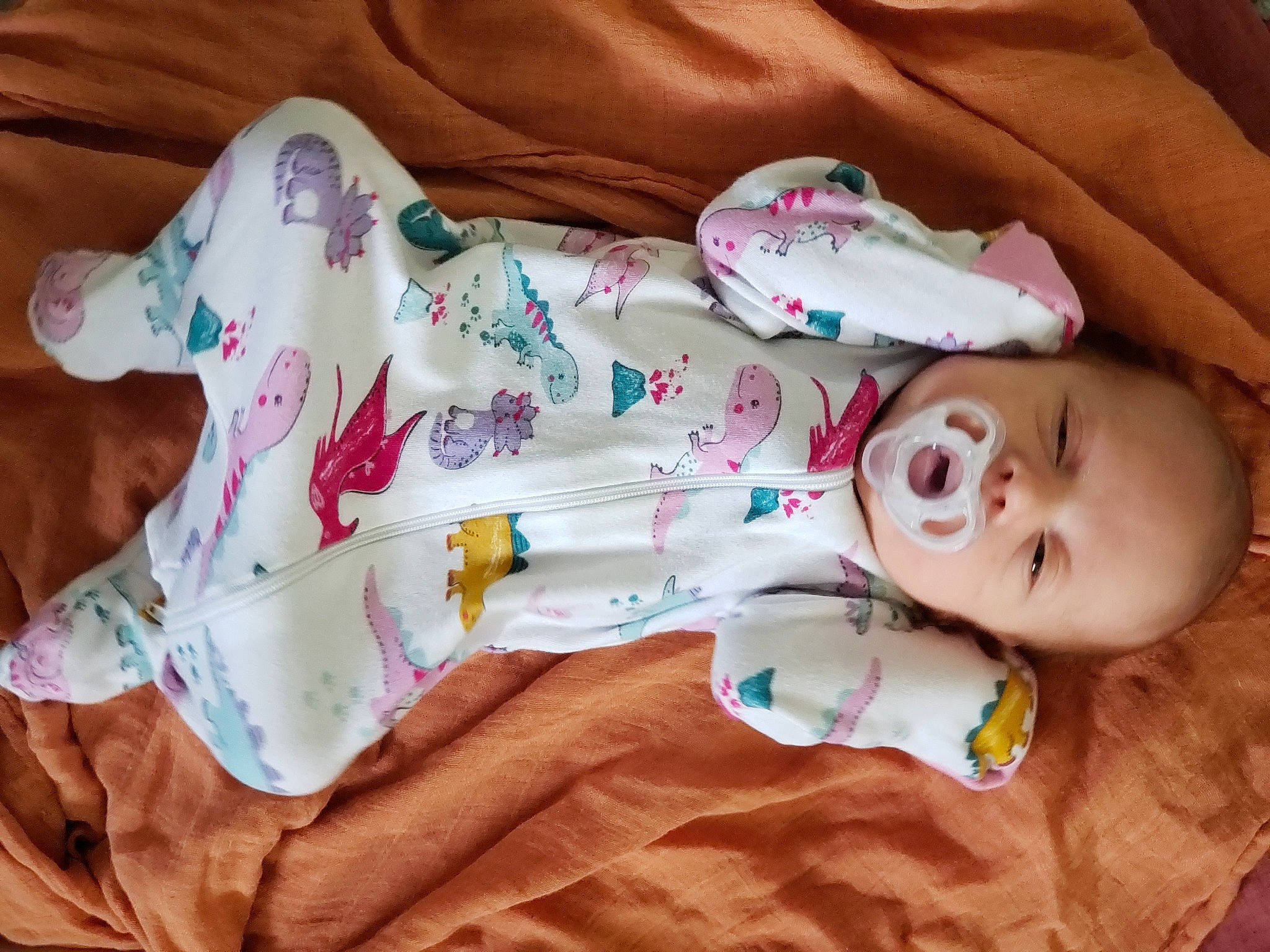 Emmy is registered to the contest to win money with this photo: arm, baby, baby_toddler_clothing, cheek, comfort, dress, eye, facial_expression, finger, glasses, hand, head, human_body, mammal, person, pink, product, skin, sleeve, textile