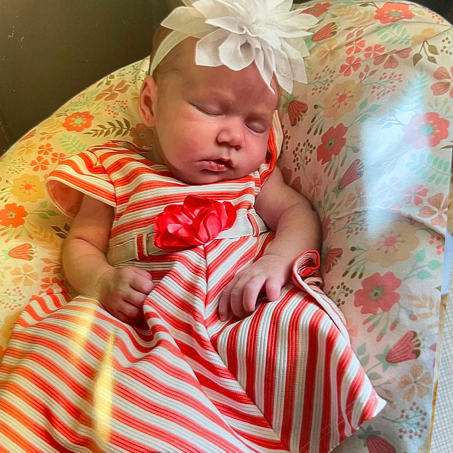 Lilian is registered to the contest to win money with this photo: adorable, baby, child, cushion, cute, dress, floral_pattern, flower_headband, headwear, indoor, infant, napping, peaceful, portrait, resting, sleeping, small_feet, small_hands, soft_lighting, striped_clothing