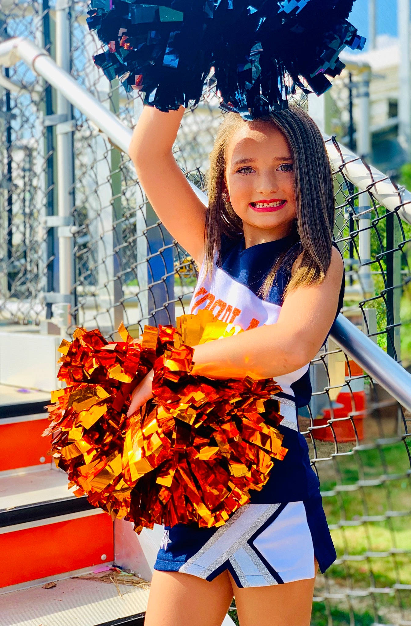 Rylann is registered to the contest to win money with this photo: beauty, blue, cheering, cheerleading, cheerleading_uniform, child_model, clothing, costume, dancer, electric_blue, joy, majorette_dancer, orange, person, photo_shoot, photography, plant, pom_pom, smile, summer