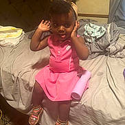 Riiver is registered to the contest to win money with this photo: toddler, child, pink_dress, sandals, bed, bottle, headband, hands, tongue_out, indoors, messy_bed, blanket, curtain, floor, furniture, person, cute, playful, hair, skin