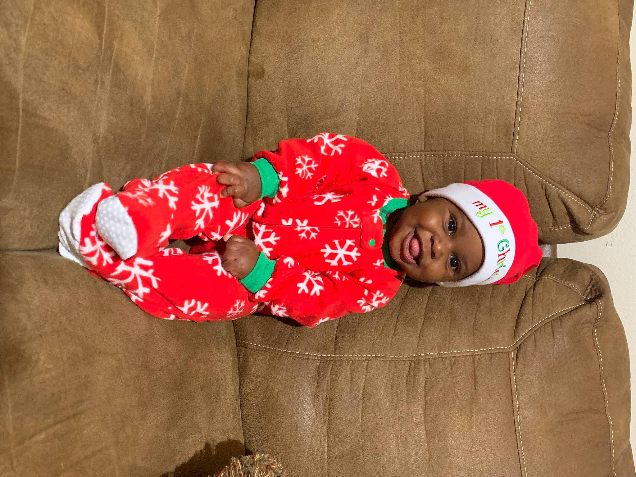 Daylen is registered to the contest to win money with this photo: baby, baby_toddler_clothing, carmine, child, christmas, comfort, couch, happy, hat, headwear, holiday, human_leg, lap, linens, magenta, pattern, person, room, sitting, sleeve
