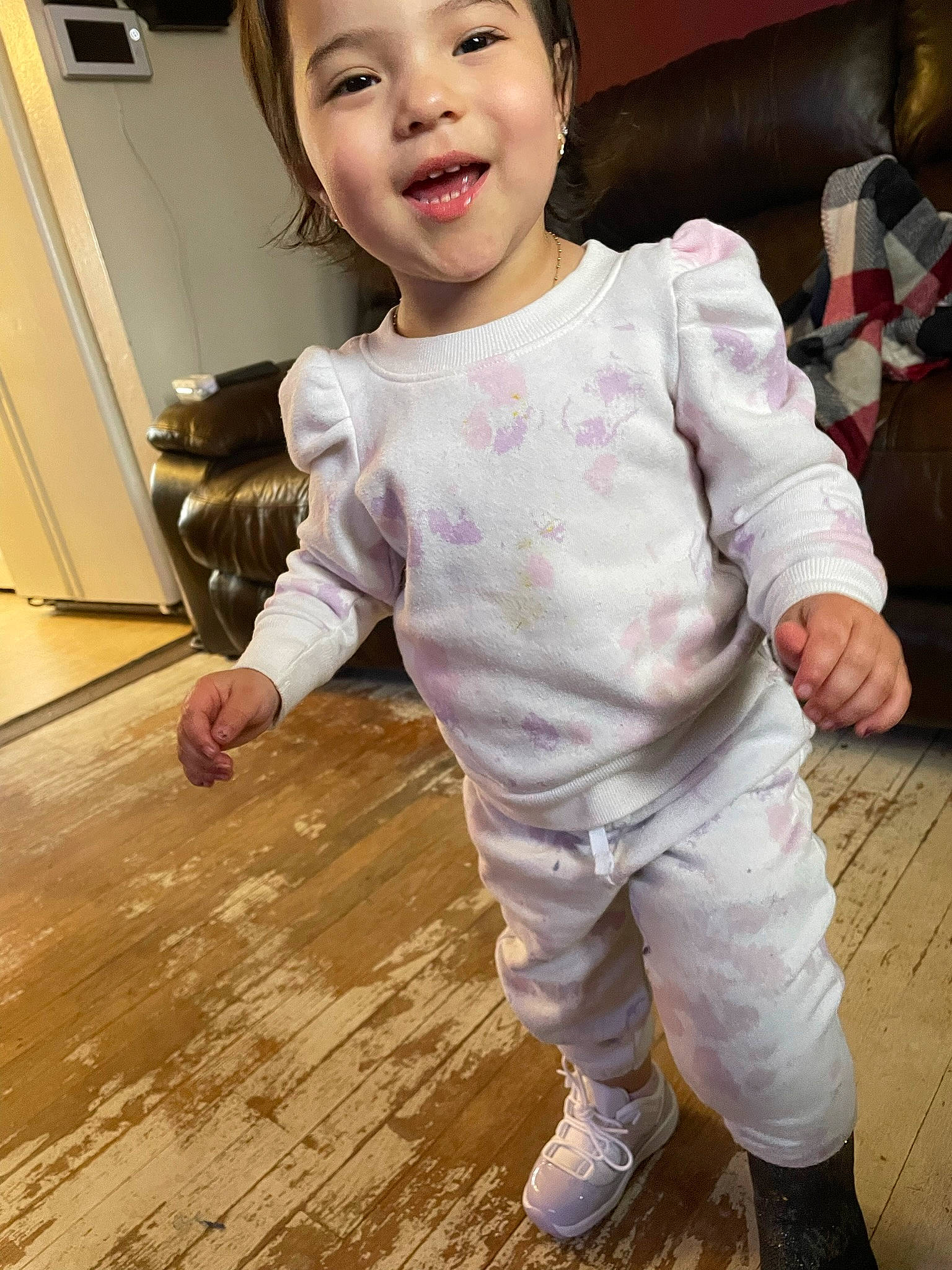 Maria is registered to the contest to win money with this photo: baby, baby_toddler_clothing, cheek, child, face, facial_expression, floor, flooring, fun, gesture, happy, hardwood, headwear, nose, person, photograph, skin, sleeve, smile, toddler