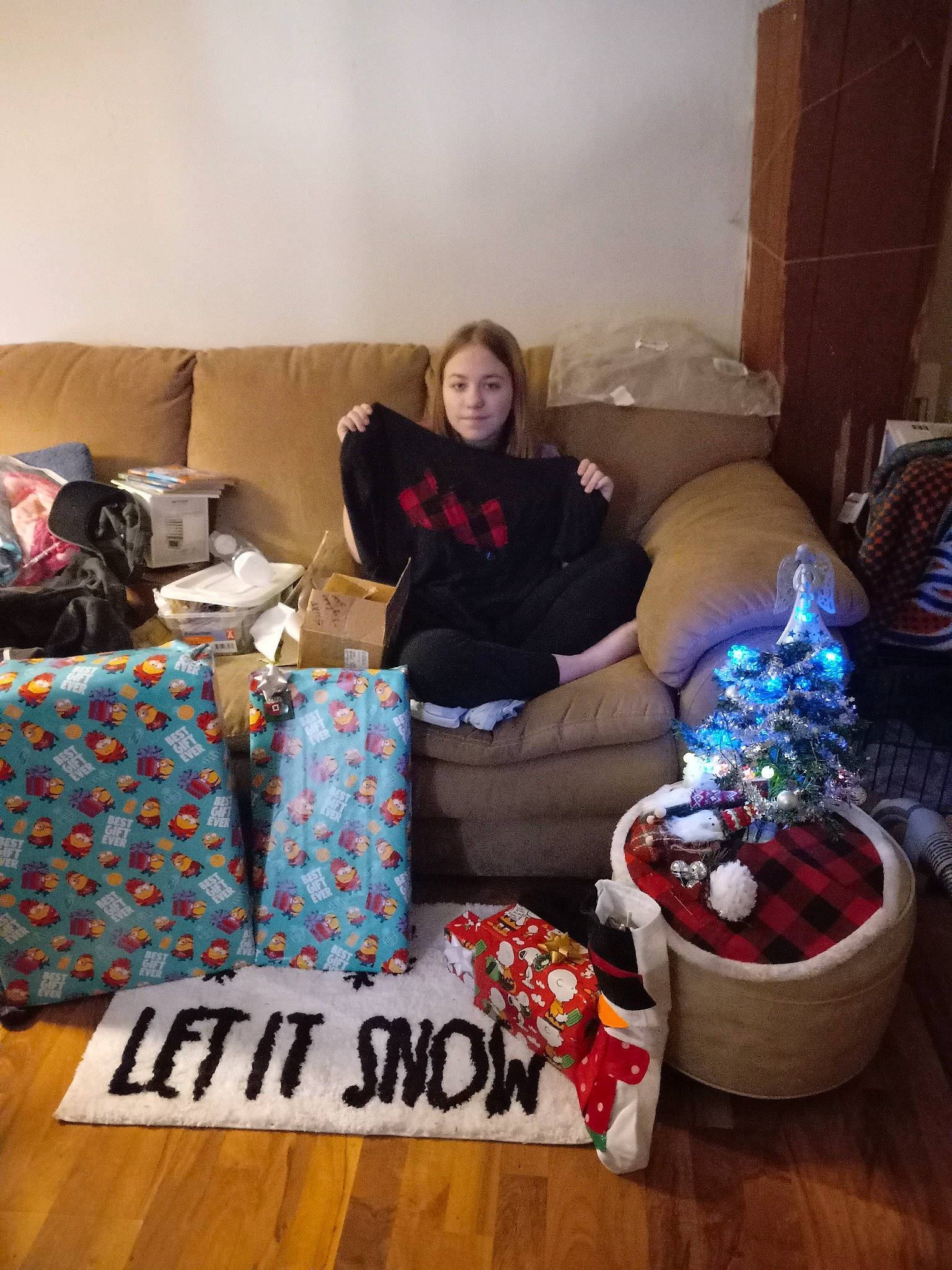 Christine is registered to the contest to win money with this photo: coffee_table, comfort, couch, event, flooring, fun, hardwood, holiday, home, interior_design, joy, lap, living_room, person, pillow, room, sitting, t_shirt, throw_pillow, tree