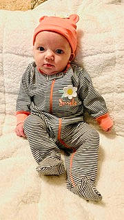 Mackenzie is registered to the contest to win money with this photo: art, baby, baby_toddler_clothing, beanie, cap, child, costume_hat, fashion_accessory, flooring, fur, hat, headwear, knit_cap, outerwear, pattern, person, sitting, skin, sleeve, toddler