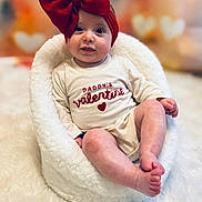 Nylah joined the competition — help win amazing prizes! baby, blurred_background, child, cozy, cute, fluffy, headband, heart, holiday, indoor, infant, love, onesie, portrait, red_bow, sitting, smiling, soft_texture, valentine, white_chair