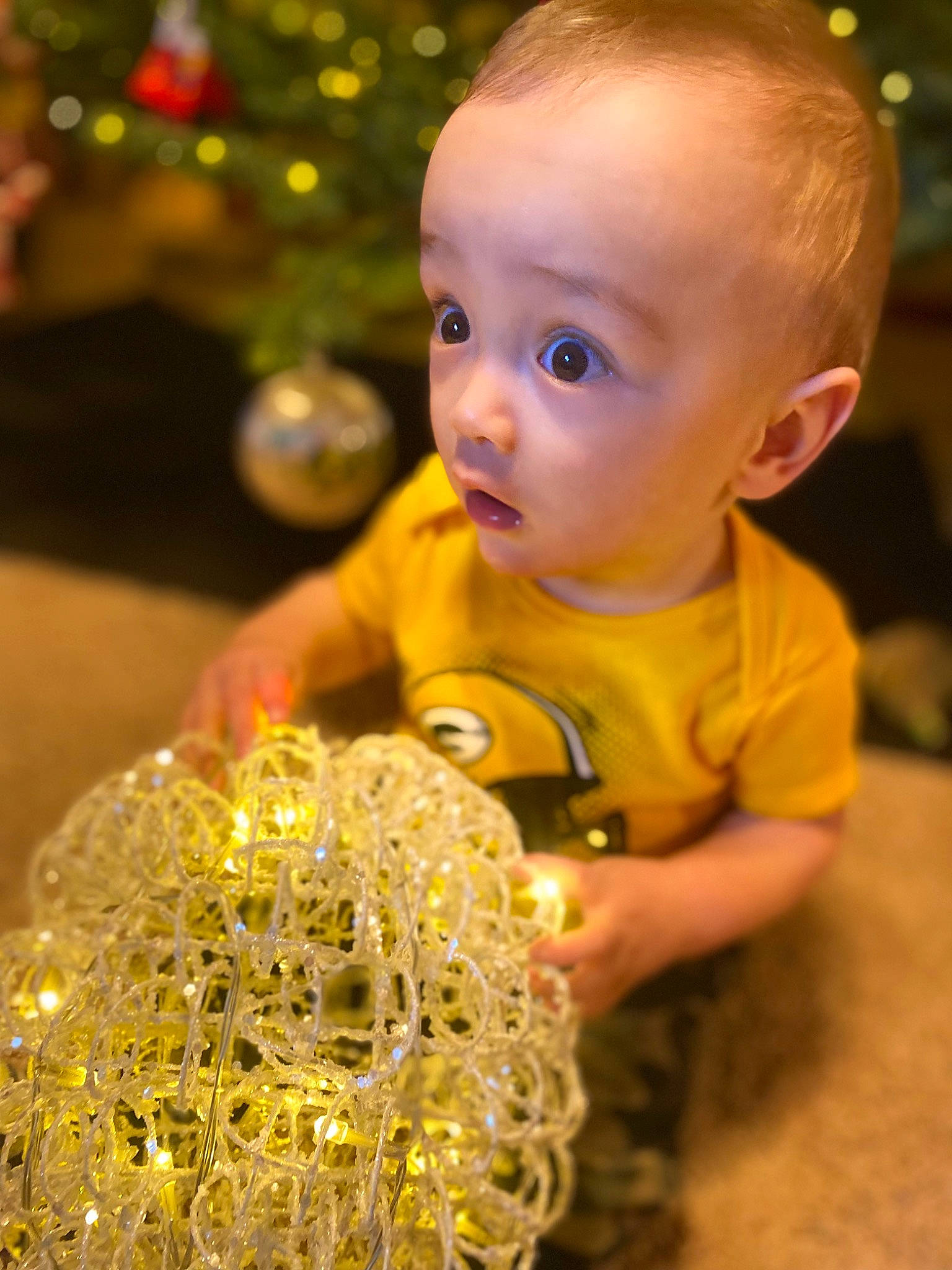 Liam joined the competition — help win amazing prizes! baby, baby_toddler_clothing, cheek, child, christmas_tree, close_up, event, flooring, fun, grass, hair, happy, holiday, iris, light, ornament, people_in_nature, person, photograph, surprise