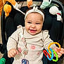 Elyna a rejoint le concours — aidez-le/la à gagner de superbes lots ! accessory, baby, child, clothing, colorful, comfort, cute, face, hand, happy, headband, indoors, infant, pacifier, person, playful, seat, smile, stroller, toy