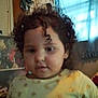 Dalilah is registered to the contest to win money with this photo: child, curly_hair, indoor, shirt, patterned_clothing, face, person, young_child, curly_hair_strand, window, curtain, home, furniture, blurred, portrait, head, expressionless, casual, light, background