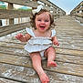 baby, child, girl, smiling, curly_hair, bow, white_dress, barefoot, boardwalk, wooden, outdoor, sand, happy, summer, nature, portrait, cute, playful, vacation, sunset