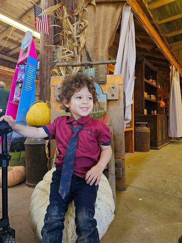 Karson is registered to the contest to win money with this photo: child, city, denim, fun, happy, human_settlement, jeans, joy, leisure, magenta, person, play, recreation, sitting, smile, standing, street, toddler, tourism, travel