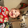 toddler, child, smiling, pajamas, colorful_clothing, indoor, living_room, couch, lamp, family_photos, happy, cute, person, portrait, home, cozy, playful, young_child, fun, casual