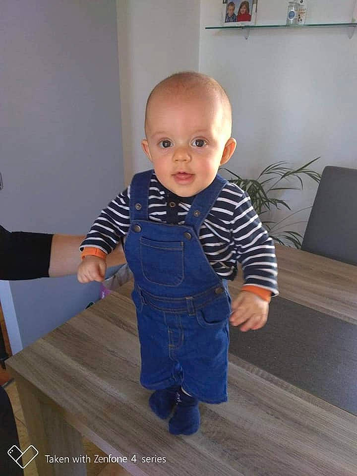 Daryl participe au concours pour gagner de l'argent avec cette photo : arm, baby, baby_toddler_clothing, blue, child, denim, face, floor, flooring, head, jeans, leg, outerwear, person, sitting, sleeve, smile, standing, t_shirt, toddler
