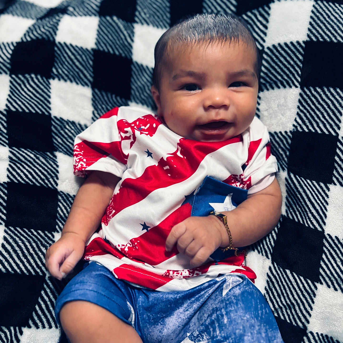 Ezran is registered to the contest to win money with this photo: baby, blanket, blue, casual, child, clothing, cozy, cute, face, happy, indoor, infant, pattern, person, portrait, red, sitting, smiling, white, young