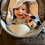 Diego a rejoint le concours — aidez-le/la à gagner de superbes lots ! baby, child, smiling, hood, stroller, toy, mickey_mouse, plush, happy, face, infant, clothing, indoor, waving, cute, person, blanket, pacifier, fabric, seated