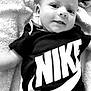 apparel, baby, black_and_white, casual, child, clothing, cute, expression, face, happy, infant, laying_down, nike, person, portrait, smiling, soft, textile, towel, young