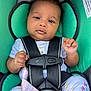 baby, car_seat, child, infant, straps, pacifier, clothing, floral_pattern, cute, seat_belt, safety, pink, teal, hand, head, portrait, person, young_child, indoors, closeup