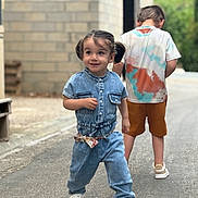 Jade a rejoint le concours — aidez-le/la à gagner de superbes lots ! child, toddler, boy, denim, jumpsuit, street, sidewalk, building, brick_wall, casual_clothing, white_shoes, pigtails, tie_dye_shirt, shorts, outdoor, smiling, walking, playful, daytime, urban