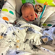 Katalyn is registered to the contest to win money with this photo: baby, newborn, infant, sleeping, blanket, baby_bouncer, baby_seat, swaddle, plush_toy, monkey, palm_tree, stars, pattern, soft_fabric, closed_eyes, face, head, hair, cozy, nursery