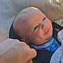 baby, blanket, blue_clothing, car_seat, child, closeup, face, hand, happy, head, indoors, infant, person, portrait, seat, seatbelt, seatbelt_strap, skin, smile, sunlight